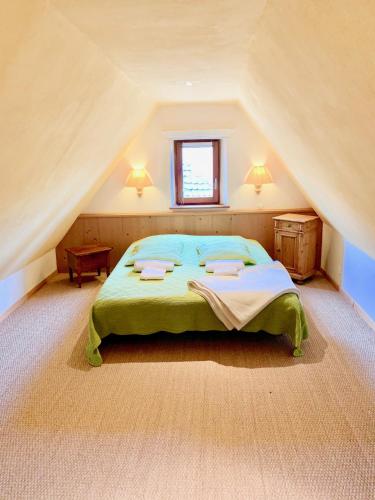 een slaapkamer met een groot bed op een zolder bij Gite "Le Muscat" à Riquewihr in Riquewihr