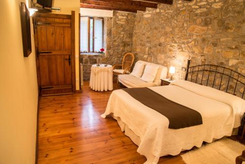 a bedroom with a bed and a stone wall at Casa Rural-Apartamentos Zelaikoa in Zestoa