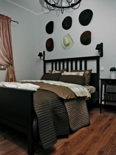 a bedroom with a bed and a wall with hats at Rancho Zapotoczny in Łagów