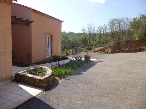 a garden with purple flowers next to a building at Domaine de Flo ADULT a partir de 16 ans in Saint-Jean-de-la-Blaquière