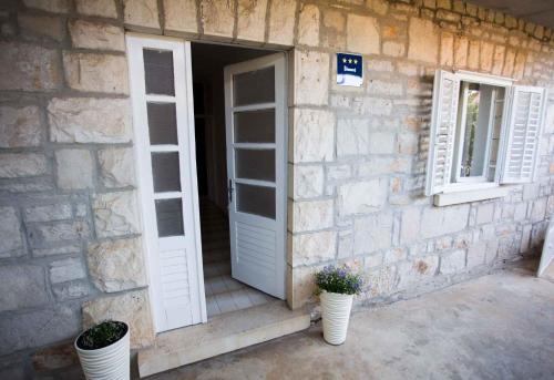 ein Steingebäude mit zwei Fenstern und einer Tür in der Unterkunft Apartment Brna 2 in Brna