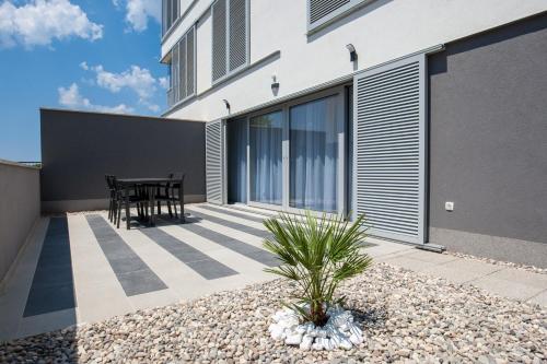 a patio of a house with a table at Apartments Dva Galeba in Bol