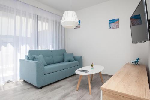 a living room with a blue couch and a table at Apartments Dva Galeba in Bol