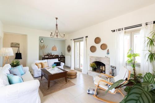 a living room with white furniture and a fireplace at Parasporos Villa - Private Pool - Beach Access in Parasporos