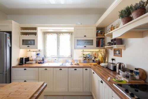 a kitchen with white cabinets and a wooden counter top at Parasporos Villa - Private Pool - Beach Access in Parasporos