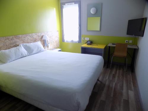 a bedroom with a large white bed and a desk at NESTOR HOTEL GAP et Restaurant in Gap