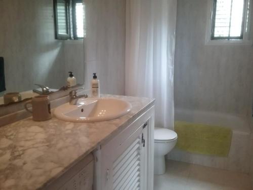 a bathroom with a sink and a toilet and a tub at Casa Sol & Mar in Sant Josep de sa Talaia
