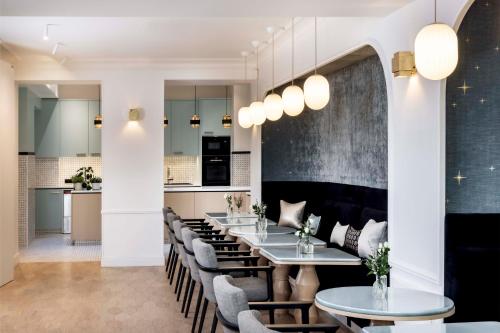 une salle à manger avec une grande table et des chaises dans l'établissement Hotel Louvre Montana, à Paris