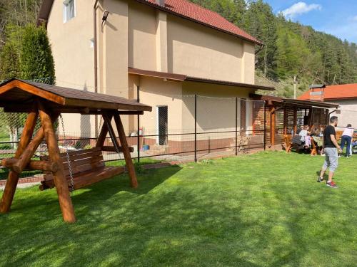 a man standing in a yard next to a house at Dendy in Brezoi