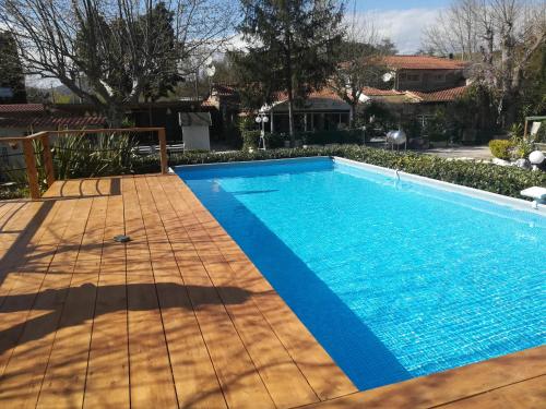 a swimming pool with a wooden floor and a blue pool at Camping Smeraldo in Trevignano Romano