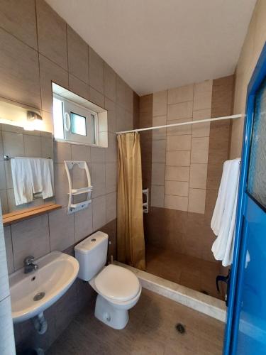 a bathroom with a toilet and a sink and a shower at Courtyard Studios in Pefki Rhodes
