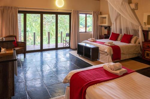 a hotel room with two beds and a television at Bushriver Lodge in Mica