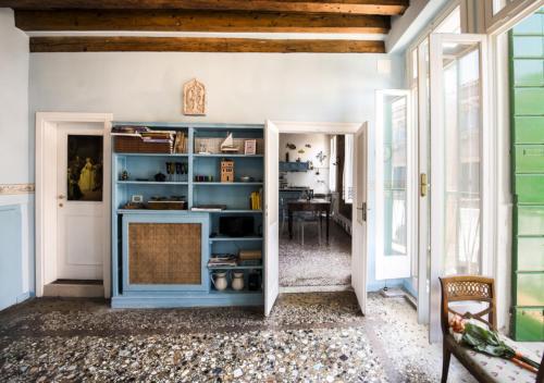 een kamer met een blauwe boekenplank en een tafel bij Venice Giardini Biennale Apartment in Venetië