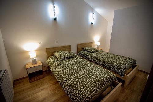 2 camas en una habitación con 2 luces en la pared en Gîte de Léonie Moulin de Tartay en Avignon, en Aviñón