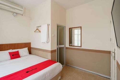 a small bedroom with a bed and a window at RedDoorz near Plaza Botania 1 Batam in Batam Center