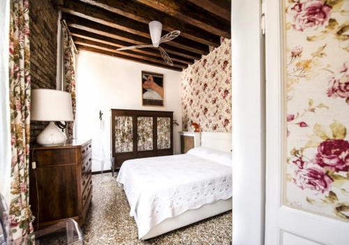 1 dormitorio con cama y papel pintado con motivos florales en Venice Giardini Biennale Apartment, en Venecia