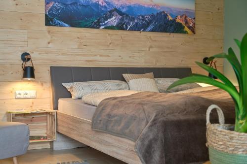 a bedroom with a large bed with a picture on the wall at Appartement Eckwald Altenmarkt-Zauchensee in Altenmarkt im Pongau