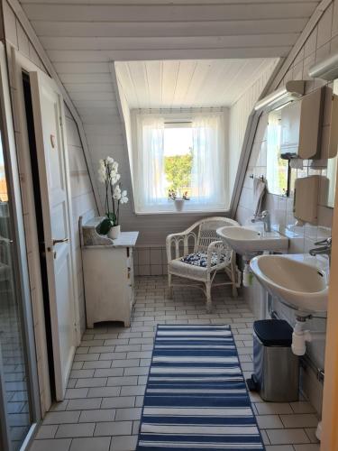 baño con 2 lavabos y ventana en Missionshuset Bed & Breakfast, en Sandhamn