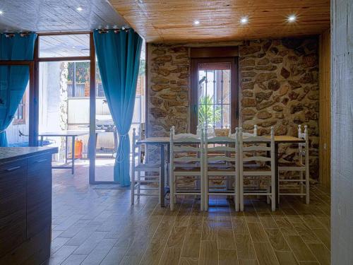 ein Esszimmer mit einem Tisch und einigen blauen Vorhängen in der Unterkunft Casa Rural Marineta Casiana - Riópar in Riópar