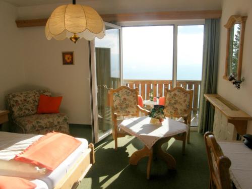 Schlafzimmer mit einem Bett, einem Tisch und Stühlen in der Unterkunft Hotel Garni Gästehaus Karin in Sankt Stefan im Lavanttal
