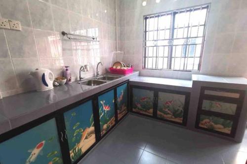 a kitchen with a counter with fish tanks at Mersing Fun Beach Home Services in Mersing