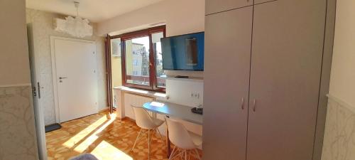 a room with a desk with chairs and a television at WILLA BAJLAND in Warsaw