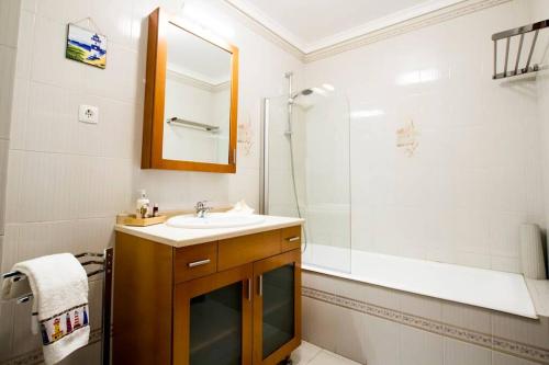 a bathroom with a sink and a shower at CASA DOS FARÓIS GARAGEM GRATUITO PRAIA DA BARRA in Gafanha da Nazaré
