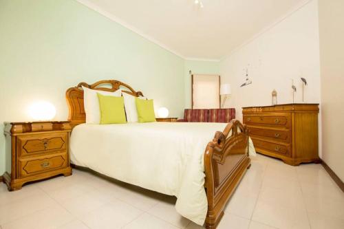 a large bedroom with a large bed and wooden furniture at CASA DOS FARÓIS GARAGEM GRATUITO PRAIA DA BARRA in Gafanha da Nazaré