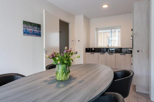 a vase of flowers on a wooden table in a kitchen at Hotel Residentie Vlissingen in Vlissingen