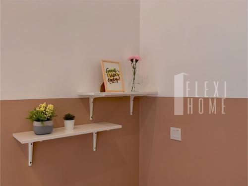a shelf with flowers and a book on a wall at Spacious Big Room, Designed & Quiet Family Home, Eclipse in Cyberjaya by Flexihome-MY in Cyberjaya