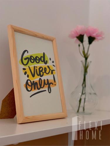 a picture frame on a shelf next to a vase of flowers at Spacious Big Room, Designed & Quiet Family Home, Eclipse in Cyberjaya by Flexihome-MY in Cyberjaya