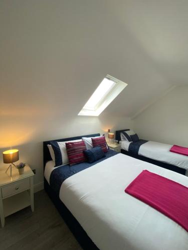 a bedroom with two beds and a skylight at Pier House Luxury Apartment in Dingle