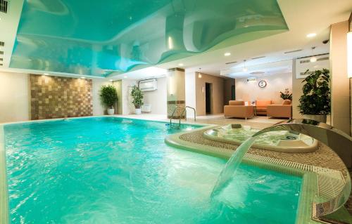 uma piscina num quarto de hotel com uma fonte de água em Victoria Hotel em Chelyabinsk
