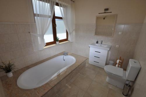 a bathroom with a tub and a toilet and a sink at Apartamenty Sowiogórskie in Pieszyce