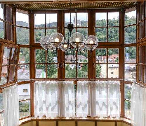 a chandelier hangs in front of a large window at VillaJazz Apartments in Murau