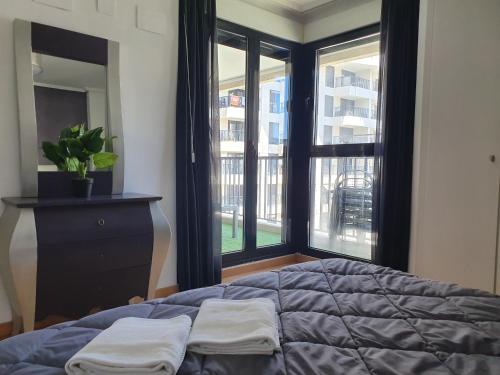 um quarto com uma cama e uma grande janela em Style Apartment Patacona Beach segunda linea em Valência