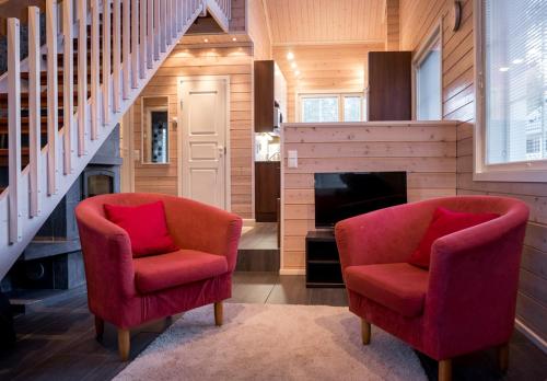 ein Wohnzimmer mit 2 Stühlen und einem Kamin in der Unterkunft Sarahovi A in Kalajoki