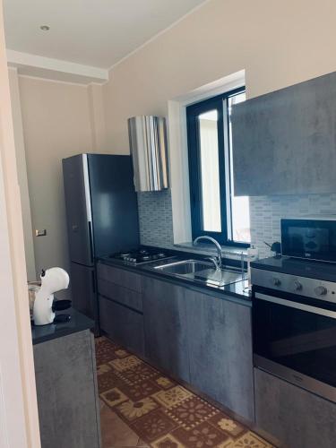 a kitchen with a refrigerator and a stove top oven at Loredana’s house in Pachino