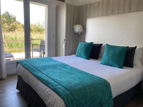 a bedroom with a large bed with a large window at Le Mas de Cocagne in Saintes-Maries-de-la-Mer