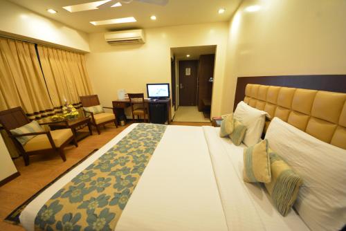 a bedroom with a large bed and a living room at The Legend Inn @Nagpur in Nagpur