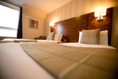 a hotel room with two beds and a window at Nevis Bank Inn in Fort William