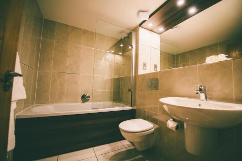 łazienka z umywalką, toaletą i wanną w obiekcie Nevis Bank Inn w mieście Fort William