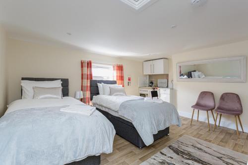 a bedroom with two beds and a table and chairs at St Mary's - Modern Central Huge Studio Apartments in Southampton