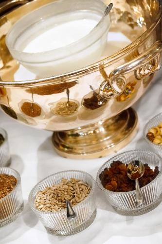 a gold platter with bowls of nuts and dried fruits at Hotel Saturnia & International in Venice
