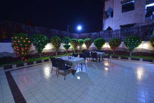 a patio with tables and chairs and christmas lights at The Legend Inn @Nagpur in Nagpur