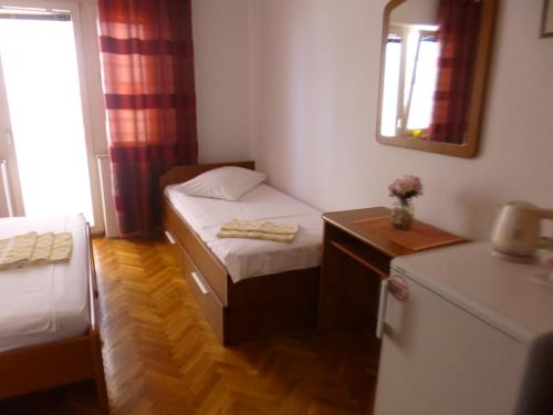 a small room with a small bed and a mirror at Haus Pehar in Baška Voda