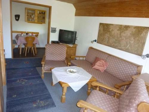 a living room with couches and a table and a tv at Apartment Strobl 1 in Strobl