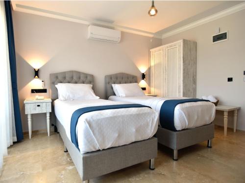 a bedroom with two beds and a table and two lamps at Tahirağa Otel in Datca
