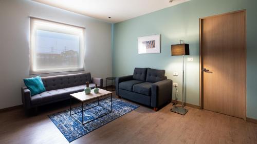 a living room with a couch and a chair at Staybridge Suites - Villahermosa Tabasco by IHG in Villahermosa