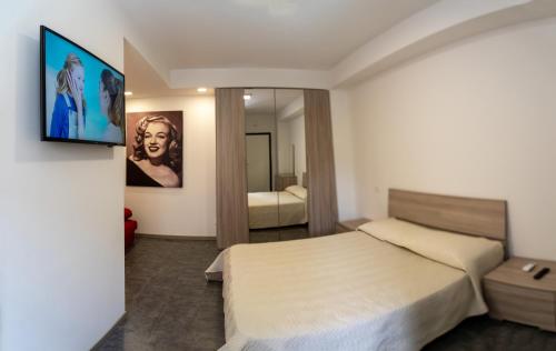 1 dormitorio con 1 cama y TV en la pared en Prestige house 4, en Scalea